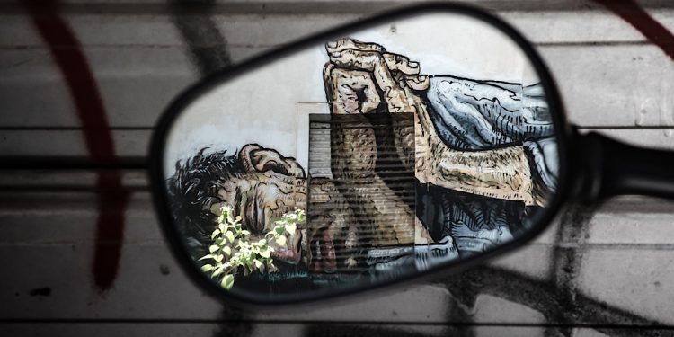 Graffiti of a homeless person reflected in a mirror