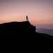 Hiker at sunrise in South Wales, standing on top of a Sandstone outcrop on Craig Yr Allt near Cardiff