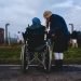 A wheelchair user and their companion visiting Auschwitz