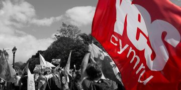 Commission finds independence viable: YesCymru flag in colour against an independence march in monochrome