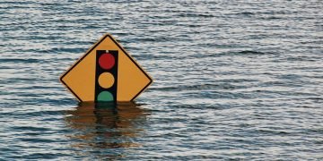 Climate change: a traffic light sign poking up out of a flood