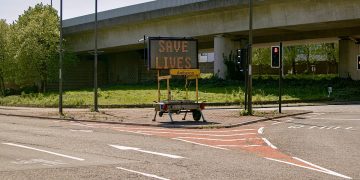 Covid Inquiry: empty road in Wales during 2020 lockdown with a sign saying SAVE LIVES